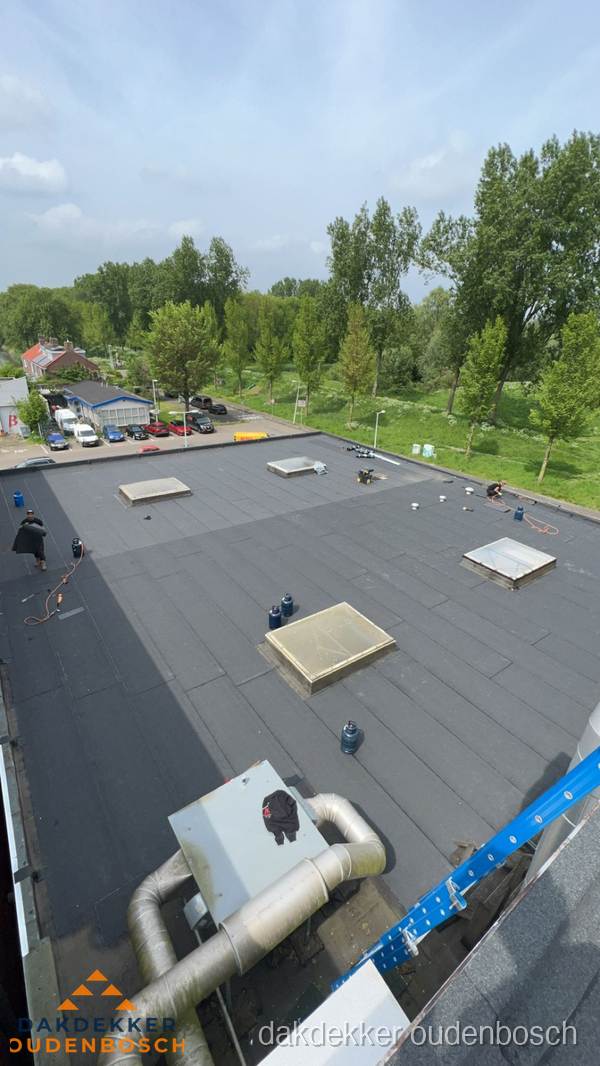 Dakdekker aan het werk op groot plat dak met bitumen in Oudenbosch Dakdekker aan het werk op groot plat dak met bitumen in Oudenbosch