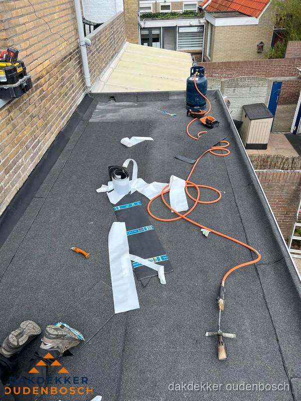 Dakdekkers bezig met bitumen dakbedekking in Oudenbosch