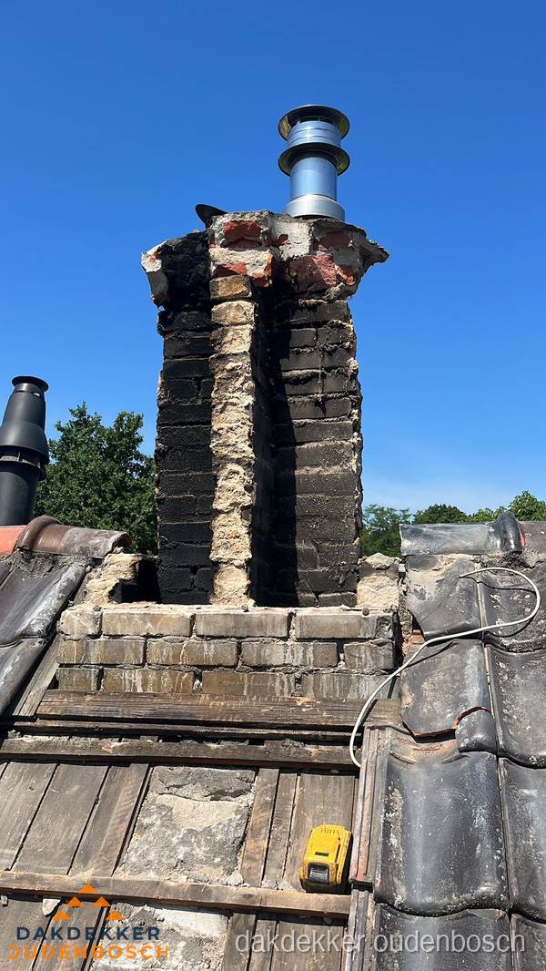 Beschadigde schoorsteen met nieuwe rookgasafvoer op oud dak in Oudenbosch Beschadigde schoorsteen met nieuwe rookgasafvoer op oud dak in Oudenbosch