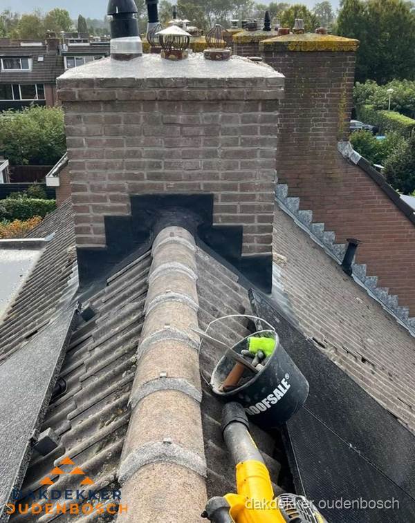 Schoorsteen met loodaansluiting en nokvorst op pannendak in Oudenbosch Schoorsteen met loodaansluiting en nokvorst op pannendak in Oudenbosch