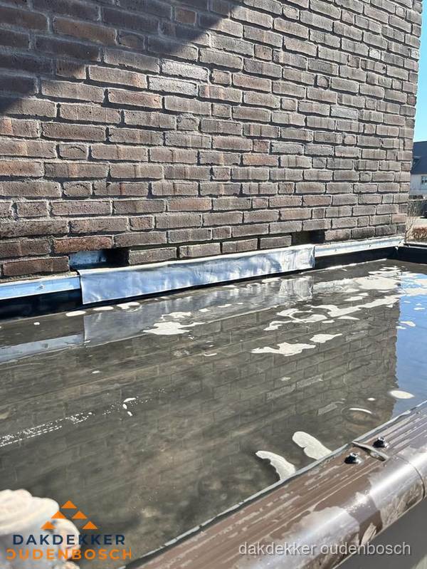 Stilstaand water op plat dak door slechte afwatering in Oudenbosch Stilstaand water op plat dak door slechte afwatering in Oudenbosch