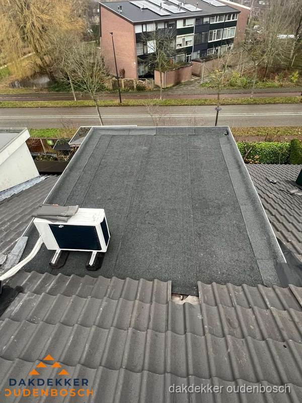 Plat dak inspectie met bitumen bedekking naast schuin pannendak in Oudenbosch Plat dak inspectie met bitumen bedekking naast schuin pannendak in Oudenbosch